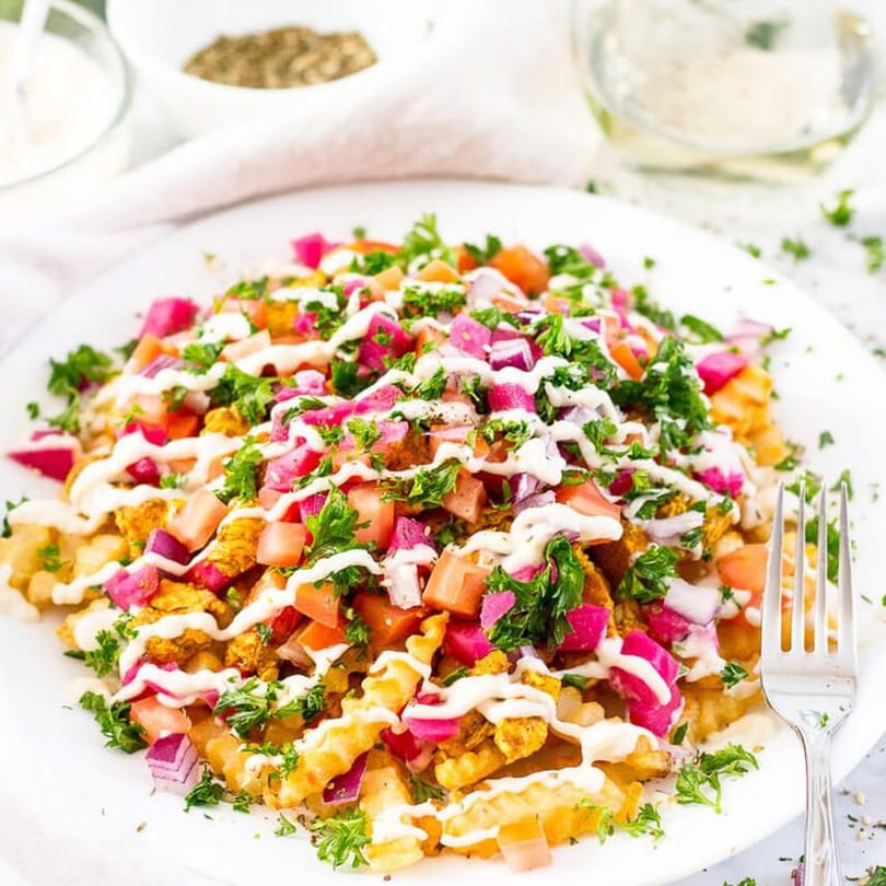 Crispy waffle fries topped with diced tomatoes, pickled red onions, parsley, and a creamy white sauce.